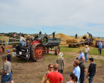 Steam tractor powering a threshing machine at Pioneer Acres